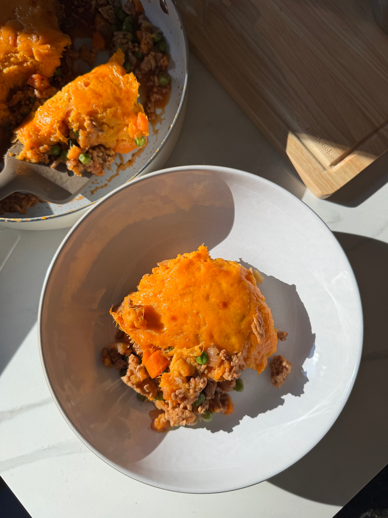 Spoon scooping sweet potato shepherd's pie showing the turkey and vegetable filling
