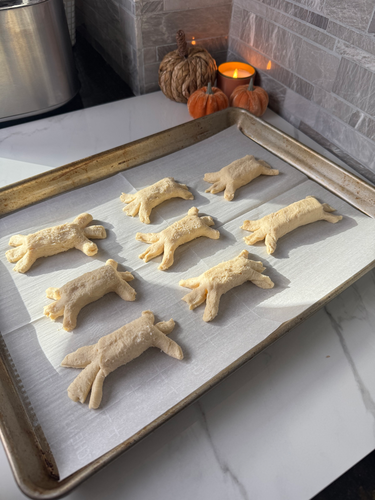 Crescent dough wrapped around cheese with ends snipped into spider legs