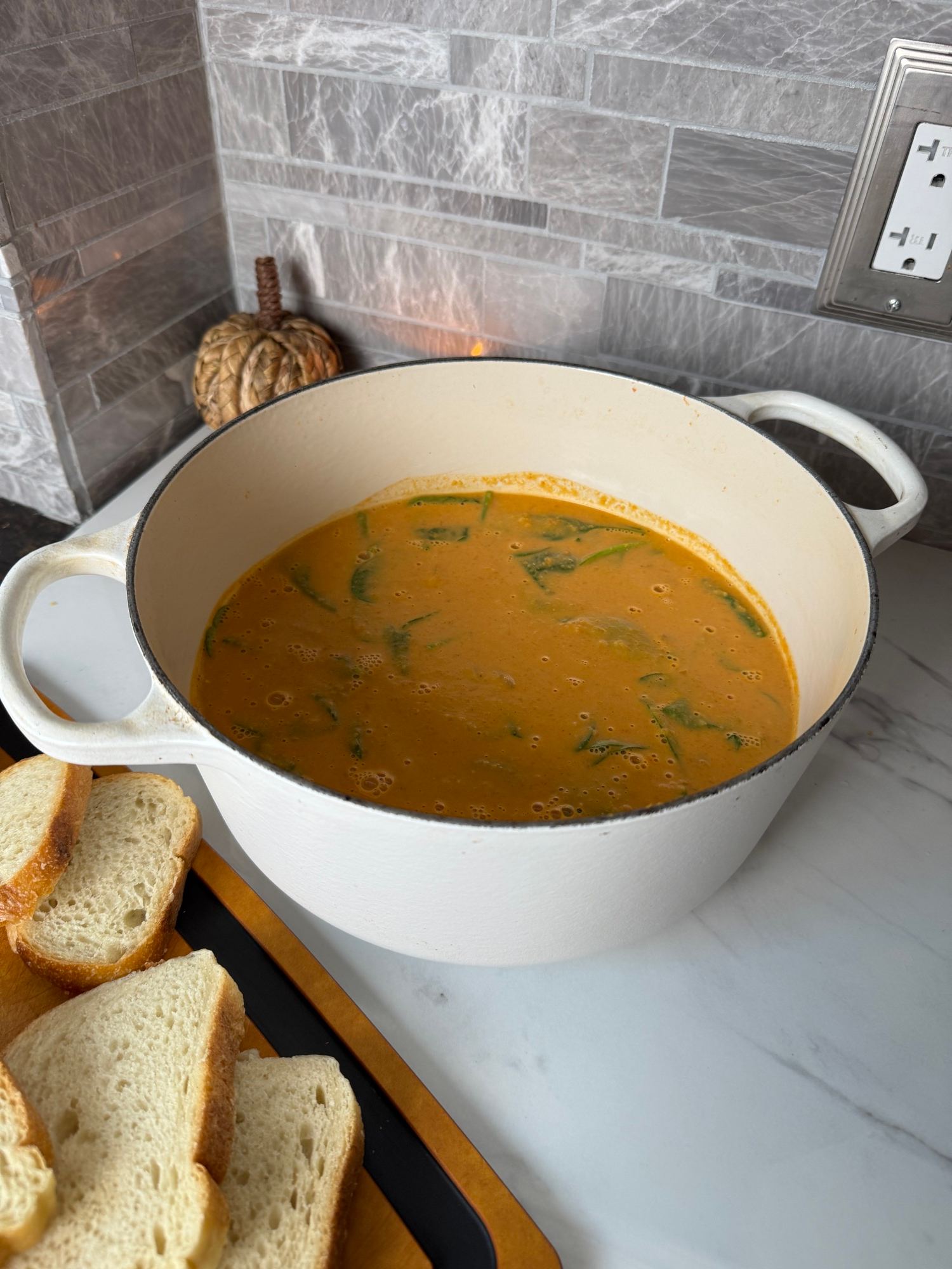Creamy spiced lentil soup in a Dutch oven served with crusty bread