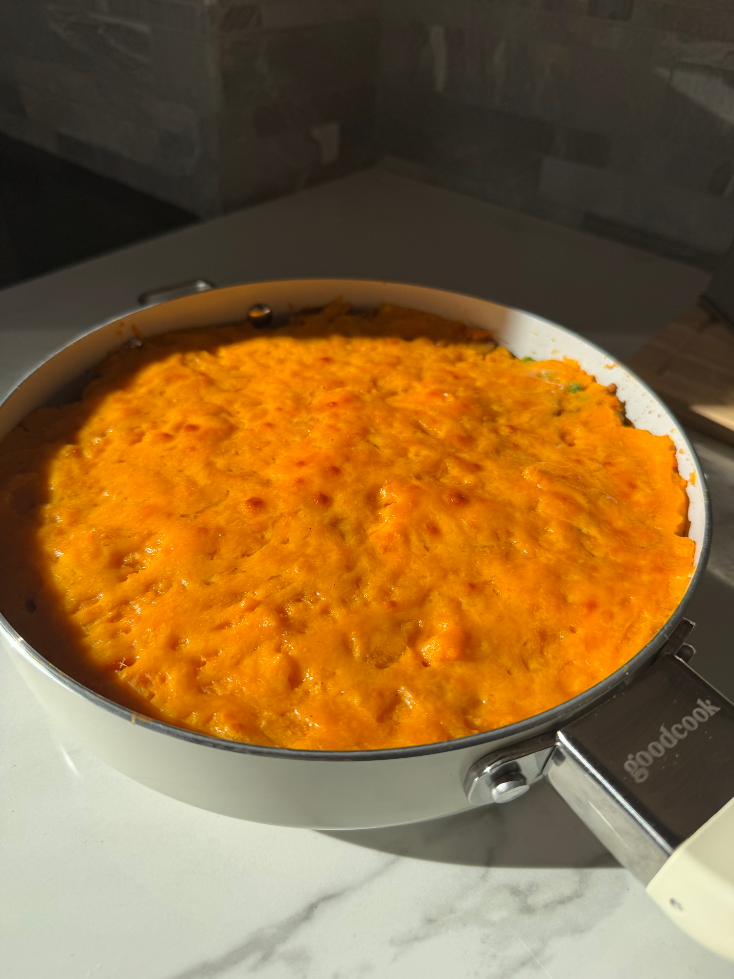 A serving of sweet potato shepherd's pie in a bowl with peas and carrots