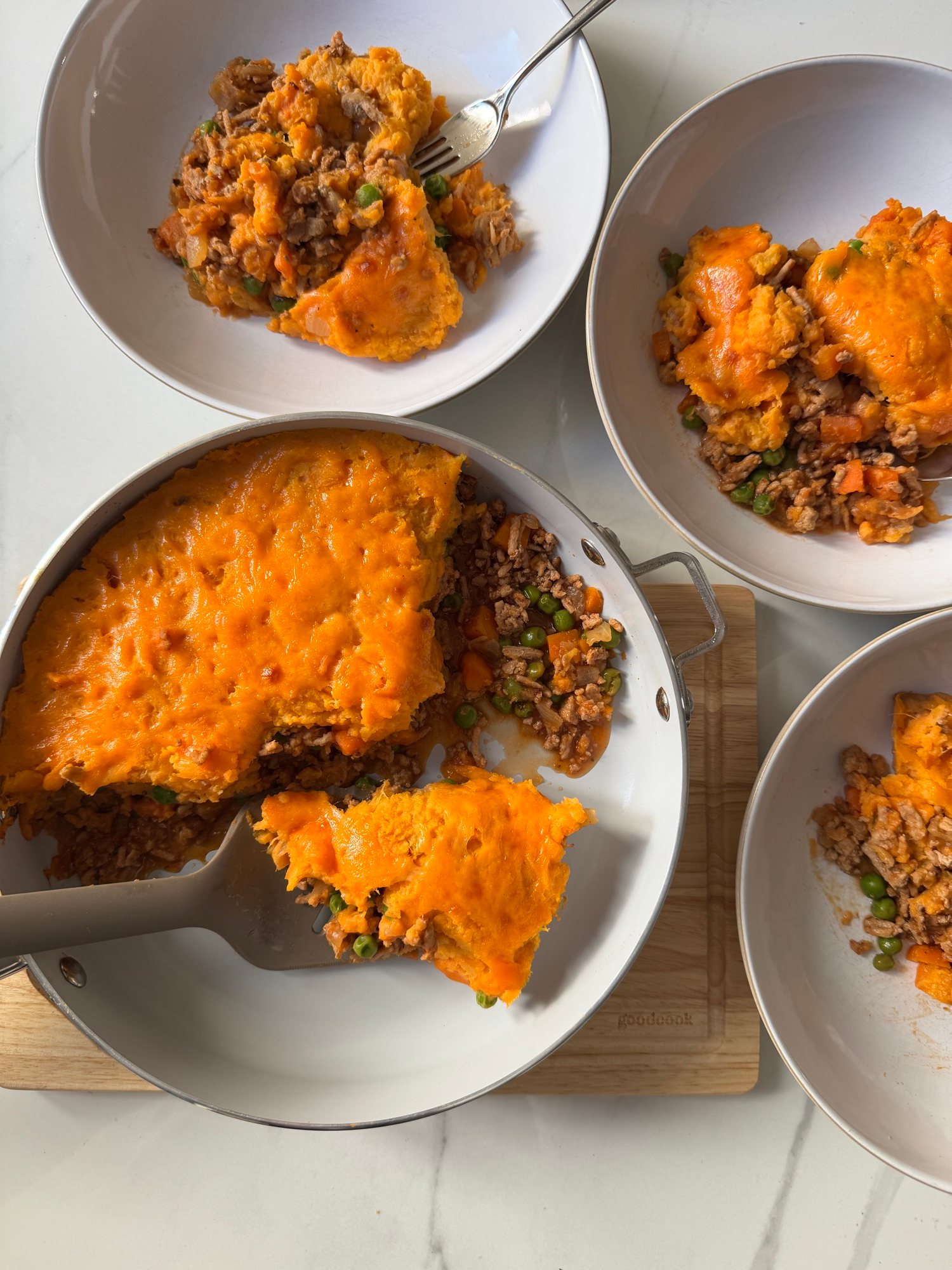 Sweet potato shepherd's pie served in bowls with cheesy topping and turkey filling
